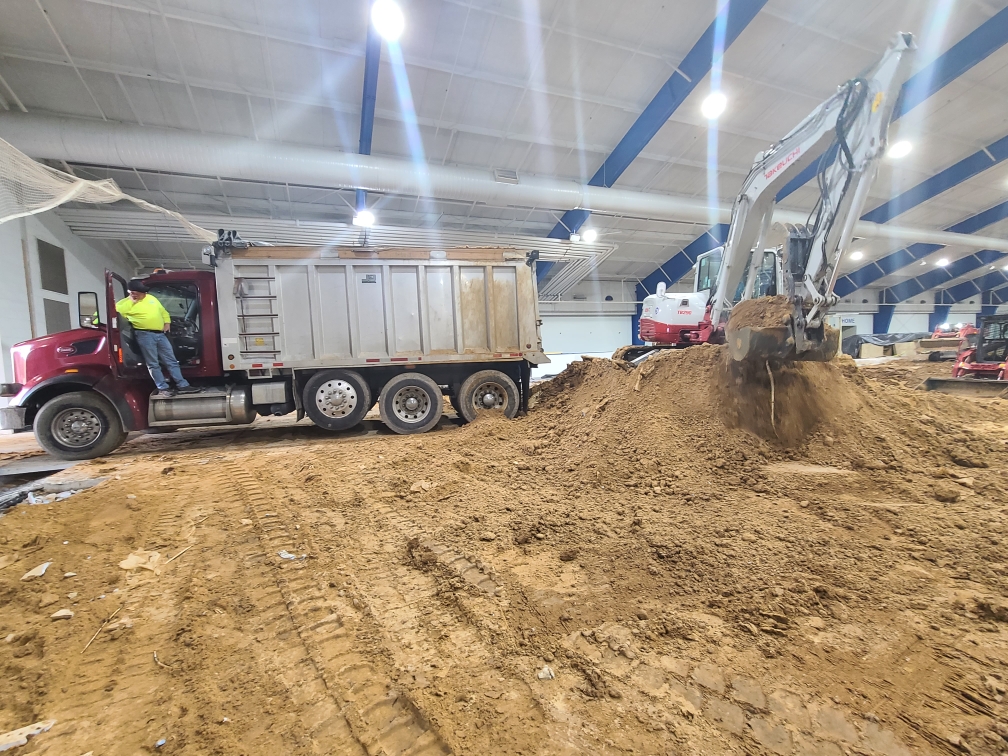 Excavator loading a dump truck during excavation work in Frederick, MD