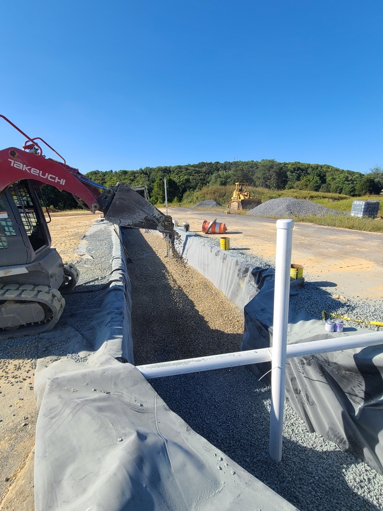 Drainage trench with liner and stone built into the grade in Frederick, MD