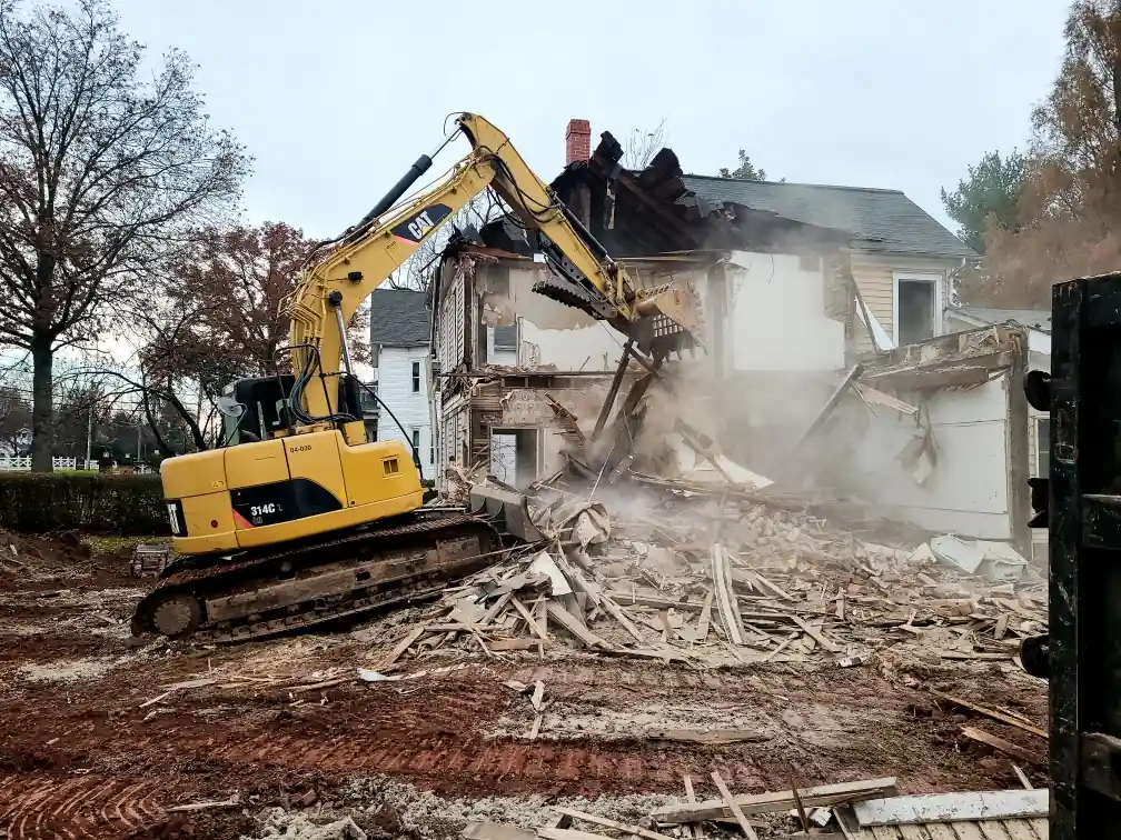 Excavator demolishing a two-story house in Frederick, MD