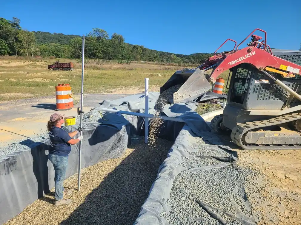 Track loader setting grade with survey equipment for excavation and grading in Annapolis, MD